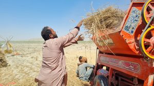 A farmer in a field next to machinery